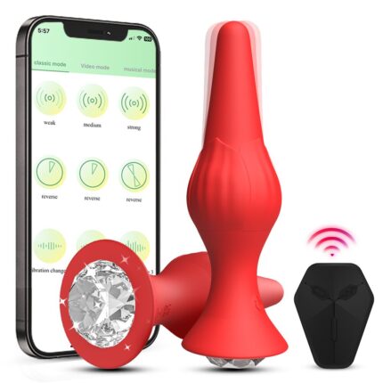 a red butt plug adorned with a clear, sparkling gem at the base. Next to it, there is a wireless remote control designed to manage its functions. Additionally, a smartphone is shown, indicating that the device can be controlled through an app, which displays various vibration modes and intensity levels. This setup highlights the device's modern, tech-savvy features aimed at providing a customizable and enhanced sensory experience.