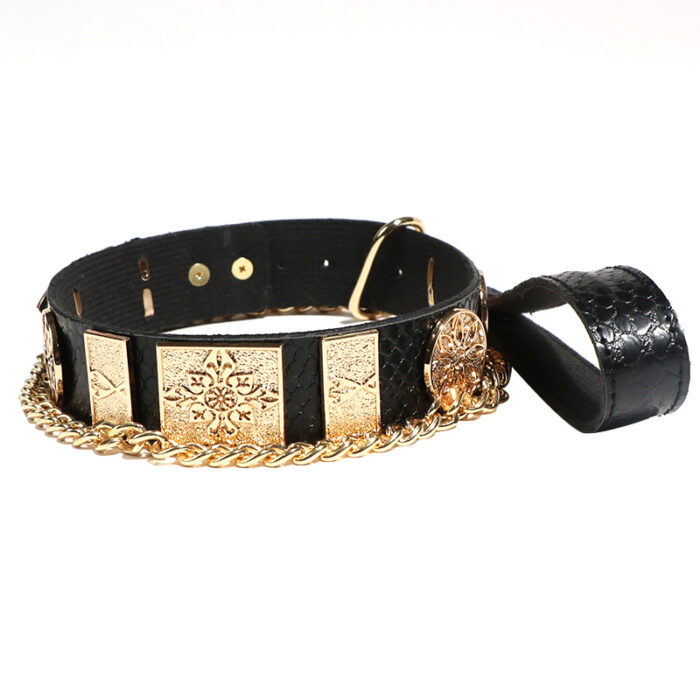 a luxurious black leather collar adorned with intricate gold detailing and a matching gold chain. The collar features embossed designs on the metal plates and a sturdy buckle for secure fastening. It is likely intended for use in BDSM or fashion contexts.