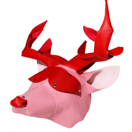 a stylized reindeer mask made of a combination of red and pink materials. The mask features prominent red antlers, pink ears, and a red nose. It is designed to cover the entire head and has an artistic and playful appearance, possibly for use in costume play or themed events. The construction appears to include rivets and seams, suggesting a hand-crafted or custom-made piece.