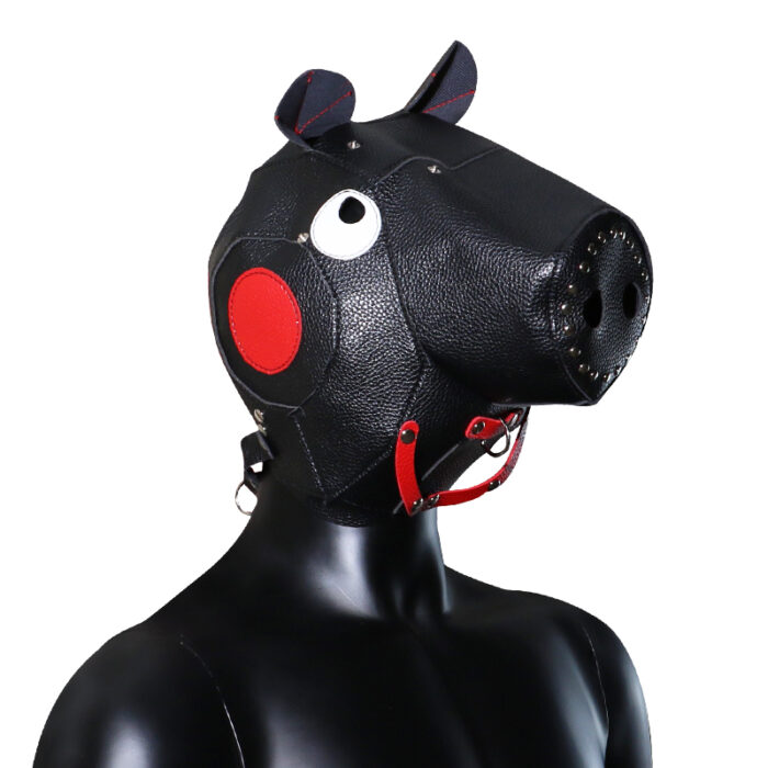 a black leather hood designed to resemble a pig's head. The hood features ears, eyes, and a snout, with red accents on the ears and sides. It includes adjustable straps and buckles to ensure a secure fit. This hood is typically used in BDSM and fetish play, providing both a visual and sensory element to role-playing scenarios.