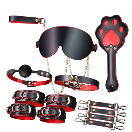 a black and red BDSM bondage set, including an eye mask, collar, ball gag, wrist and ankle cuffs, a leash with a chain, a paddle with a paw print design, and connecting straps. The set is designed for intimate play, offering various accessories for enhanced sensory and restraint experiences.