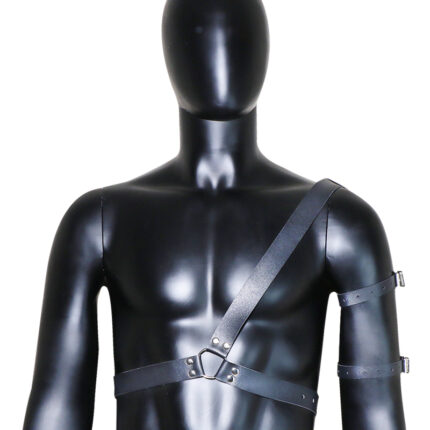 a black leather harness worn on a mannequin. The harness features a single strap across the chest and another strap wrapping around the arm, secured with metal buckles. It is designed for both aesthetic and functional purposes in BDSM activities, providing a stylish and durable accessory for bondage play.