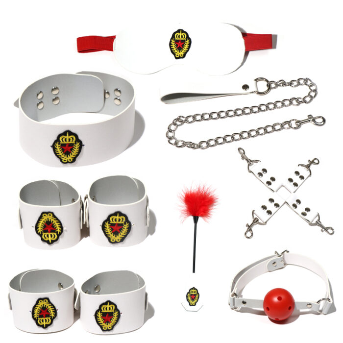 a set of white bondage accessories, including an eye mask, a collar with a chain leash, wrist and ankle cuffs, a ball gag, a feather tickler, and connecting straps. Each item is adorned with a distinctive emblem featuring a crown and a crest, adding a unique touch to the set. These accessories are designed for sensory play and BDSM activities, offering a stylish and intimate experience.