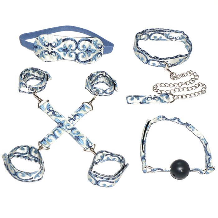 a set of blue and white patterned bondage accessories, including an eye mask, a collar with a chain leash, wrist and ankle cuffs, and a ball gag. Each item is adorned with an intricate floral design, adding a touch of elegance to the set. These accessories are designed for sensory play and BDSM activities, offering a visually appealing and intimate experience.