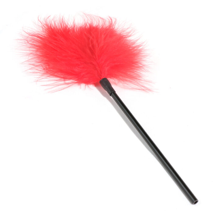 a red feather tickler attached to a black handle. The feather tickler is designed for light, sensual touch play, often used in BDSM and other intimate activities to enhance sensation and increase arousal. The soft feathers provide a gentle tickling effect, making it a popular choice for playful teasing during intimate moments.