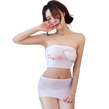 A woman is wearing a strapless white bandeau top and a matching mini skirt. The bandeau top has a red heartbeat line design that forms a heart shape. She is posing with one hand near her face and the other resting on her hip, emphasizing the playful and flirty nature of her outfit.