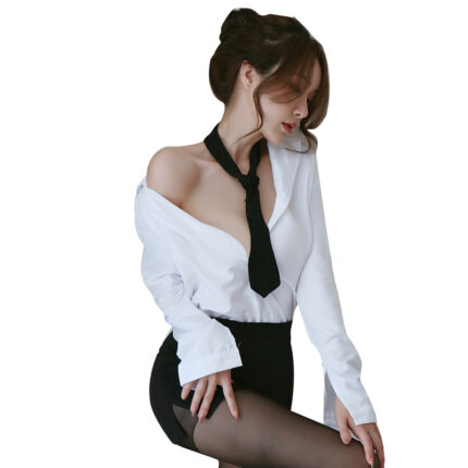 A woman dressed in a white button-down shirt partially open, revealing her shoulders. She wears a black tie, black shorts, and sheer black stockings, posing with an elegant and seductive demeanor.