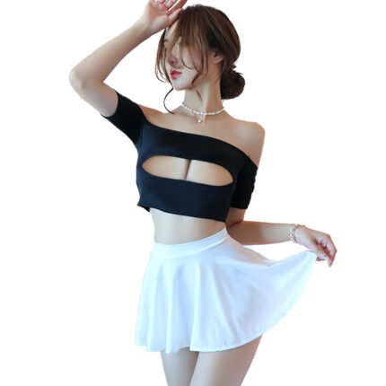 A woman in a stylish outfit featuring a black off-shoulder crop top with a cutout design and a white mini skirt. She poses with one hand raised and the other holding the skirt.