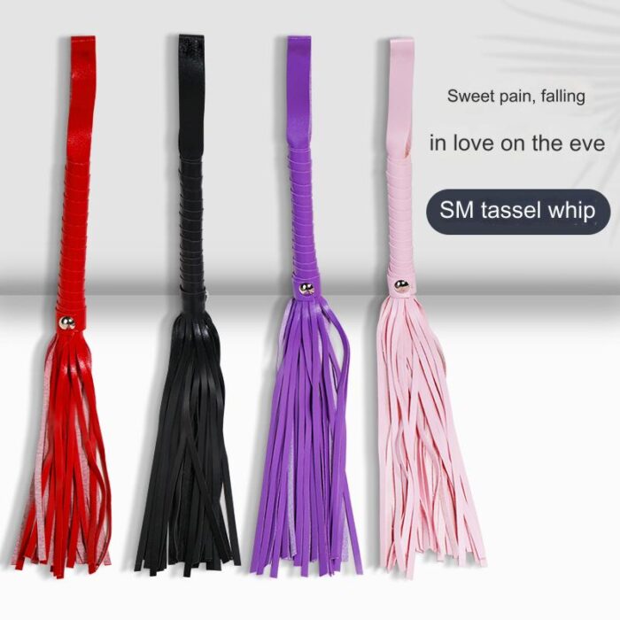 four SM tassel whips in different colors: red, black, purple, and pink. Each whip has a braided handle and multiple tassels. The text on the image reads "Sweet pain, falling in love on the eve" and "SM tassel whip," highlighting the product's use in BDSM and role-play activities.